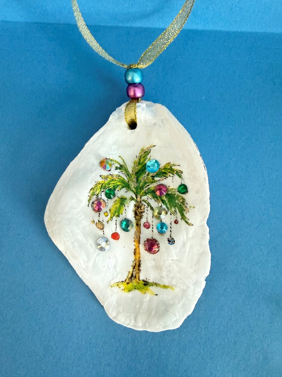 Oyster shell ornament with a palm tree hung with sparkling jewels